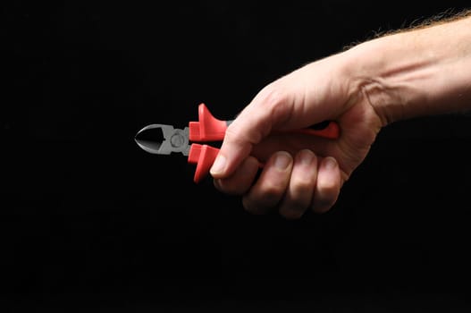 Cutter Pliers and Hand on a Black Background