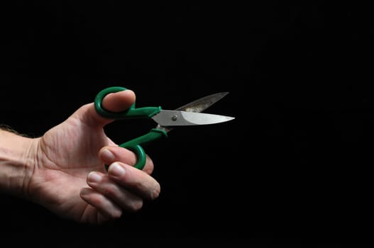 Scissors and Hand on a Black Background
