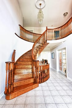 Curved oak staircase in luxury home entrance hall