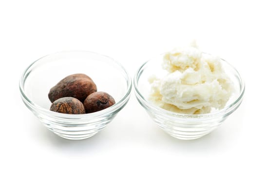 Shea butter and nuts in glass bowls isolated on white
