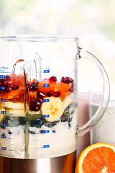 Closeup of healthy smoothie ingredients in blender with fresh fruit