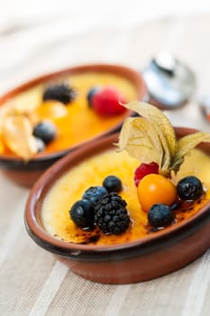 Sweet creme brulee desserts topped with fresh berries