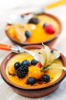 Sweet creme brulee desserts topped with fresh berries