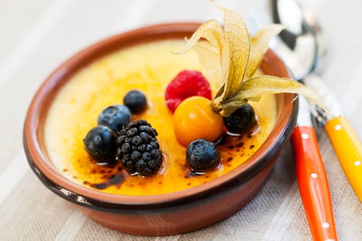 Sweet creme brulee desserts topped with fresh berries