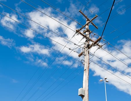 Australian electricity grid with power pole and power lines against blue sky