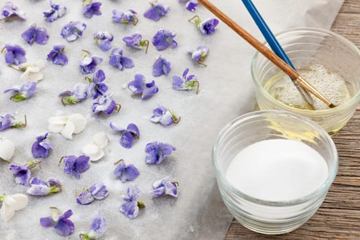 Making candied violet flowers with egg whites and sugar