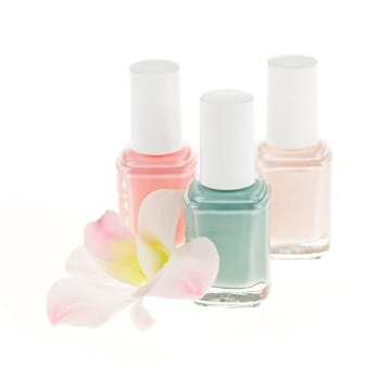 Three nail polish bottles with orchid flower on white background