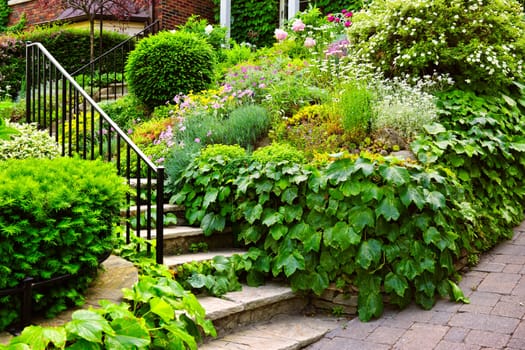 Landscaped garden path with natural stone steps and metal railing