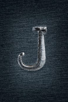 Macro image of the letter "J"" in metal"