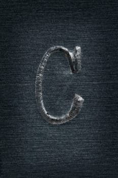 Macro image of the letter "C"" in metal"