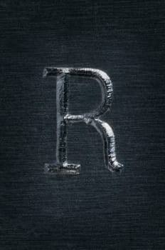Macro image of the letter "R"" in metal"