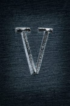 Macro image of the letter "V"" in metal"