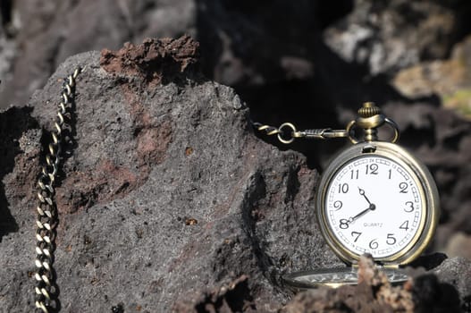 Time Concept Classic Vintage Pocket Clock on the Volcanic Rocks