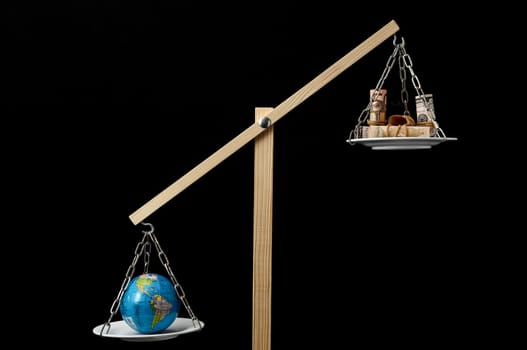 Globe Planet Earth and Money on a Two Pan Balance