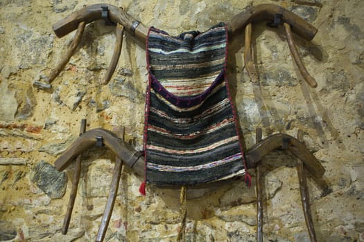 Two wooden yoke hanging on a stone wall with saddlebags, Badajoz, Spain