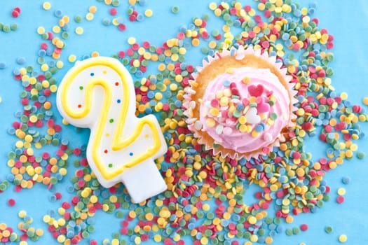Small colorful cupcake with pink sprinkles for second birthday