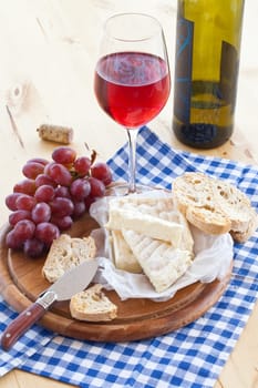 A glass of red wine,caese and fresh baguette