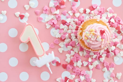 Small colorful cupcake with pink sprinkles for first birthday