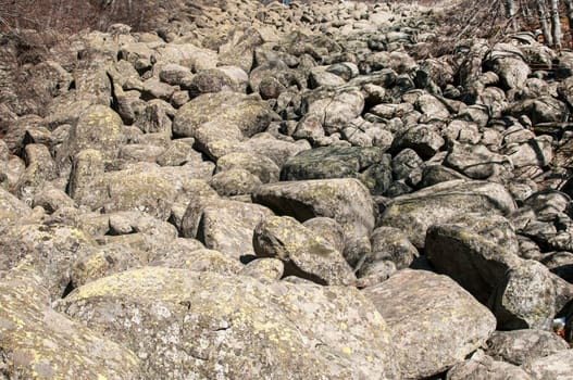 Old moraine rocks with moss in winter sunny day landscape