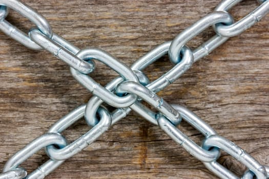 Steel chains crossed on the wooden background