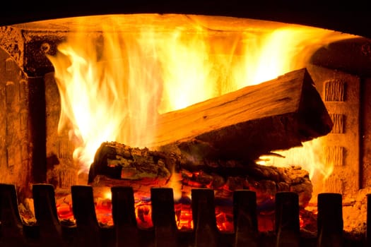 Fire place detail of a fire burning inside.