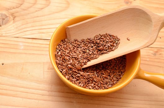 Flaxseed in a ceramic bowl on a wooden table