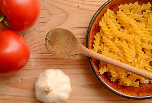 Pasta ingredients on a wooden background