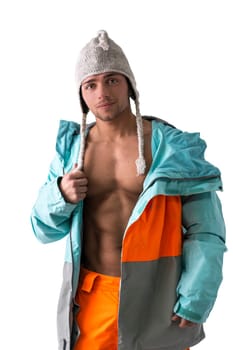 Attractive young male skier or snowboarder with open coat on naked muscular torso