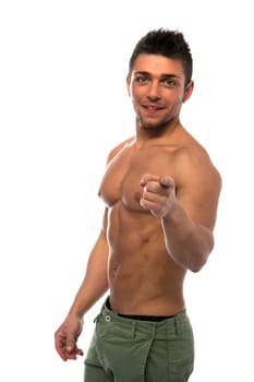 Confident, smiling young man shirtless with muscular torso, ripped abs and pecs, pointing finger to camera