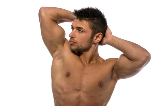 Attractive young muscle man showing athletic torso and biceps, hands behind his head