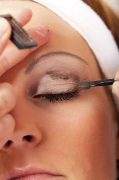young woman with makeup almost finished