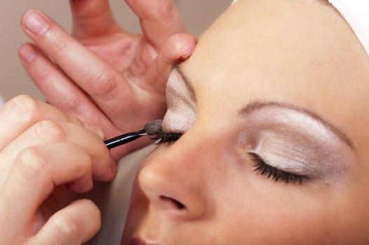 Beautician at makeup of the eyelids