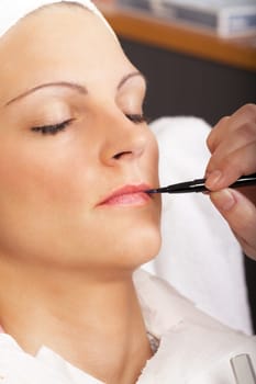 beautician carries with brush on lip color
