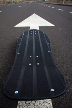 Vintage Style Longboard Black Skateboard on an Empty Asphalt Desert Road