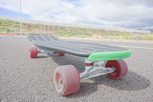 Vintage Style Longboard Black Skateboard on an Empty Asphalt Desert Road