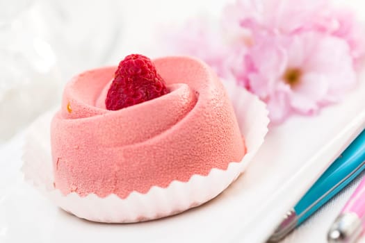 Closeup of pink raspberry mousse dessert with cherry blossom