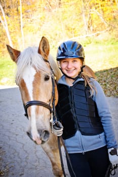 Portrait of teenage girl with horse outdoors on sunny day