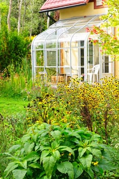 Exterior of glass solarium and garden at home