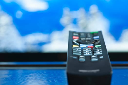 Television remote control closeup pointing at tv