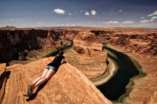 Woman looks over the edge of the abyss at the Grand Canyon,Arizona,USA