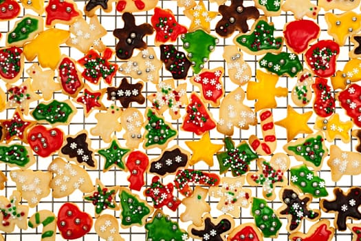 Cooling rack with freshly baked homemade shortbread Christmas cookies on white background from above