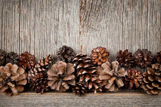Rustic natural wooden background with pine cones
