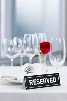 Reserved romantic table setting with roses plates and cutlery