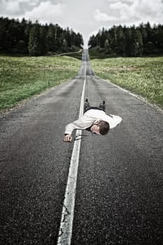 businessman lying down on long road