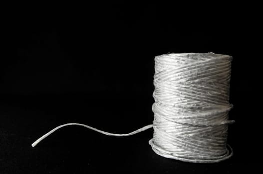 Roll of White Twine on a Black Background