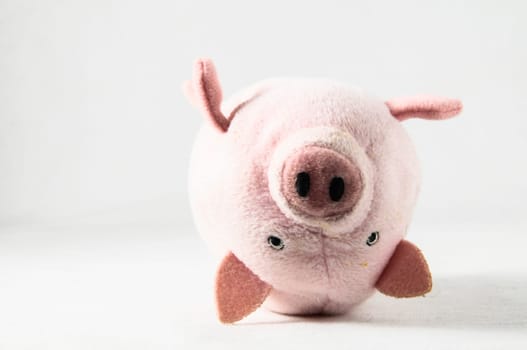 The pink pig cloth figurine on a white background