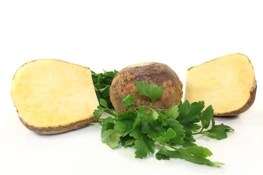 two turnips and parsley against a white background