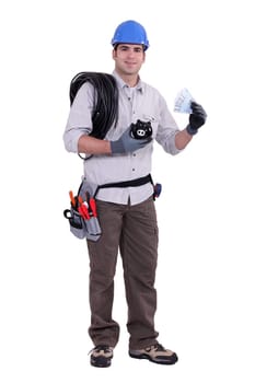 Construction worker holding a piggy bank and money