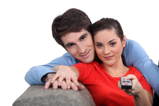 Couple sitting on a sofa with a remote control