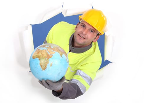 craftsman breaking a paper wall and holding a globe